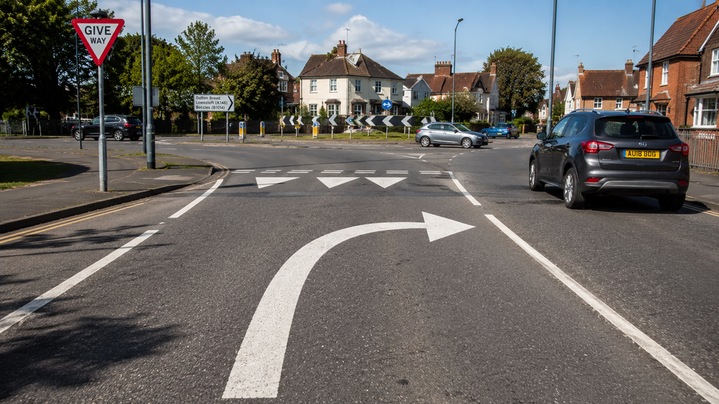 Curved arrow road marking meaning for UK drivers at a junction